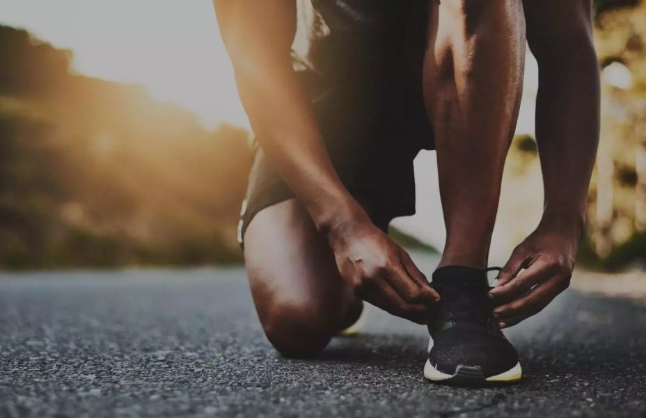 close up of male tying his shoelace ready for a run